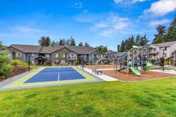 Tennis Courts and Playground, Wood Chip Floor, Grass, and Apartment Exteriors